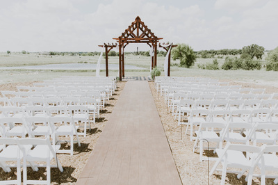 outdoor wedding ceremony ranch with large backdrop and water