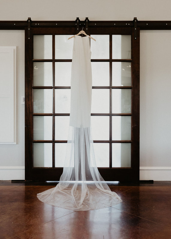 indoor reception area with bridal gown hanging on farm house doors