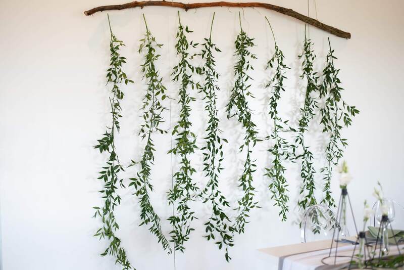 natural backdrop greenery and white wall honey do event rentals